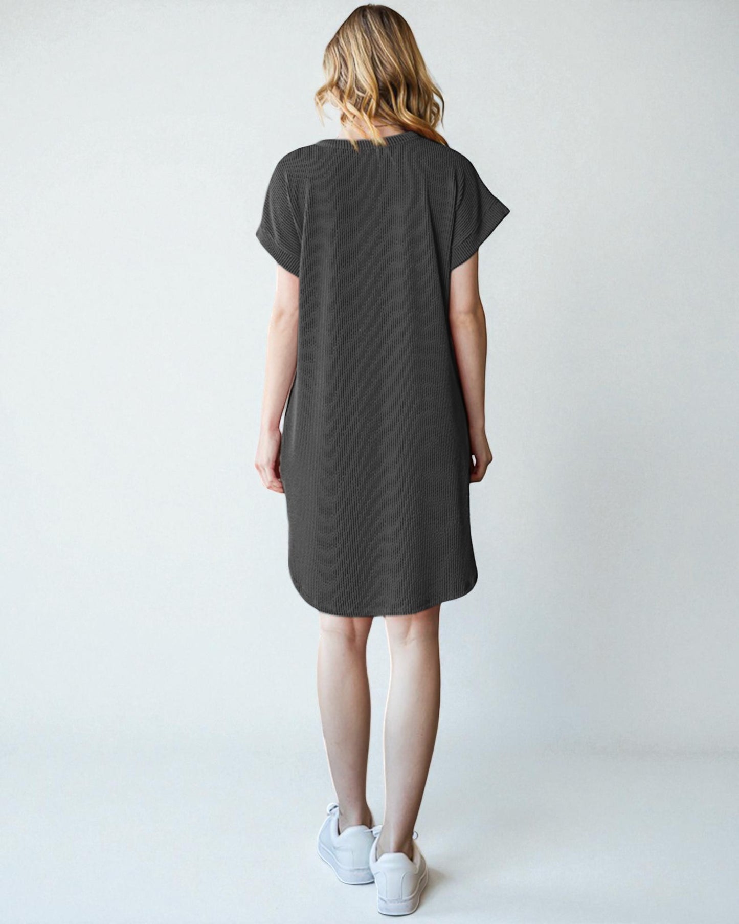 Woman wearing a gray dress against a white background