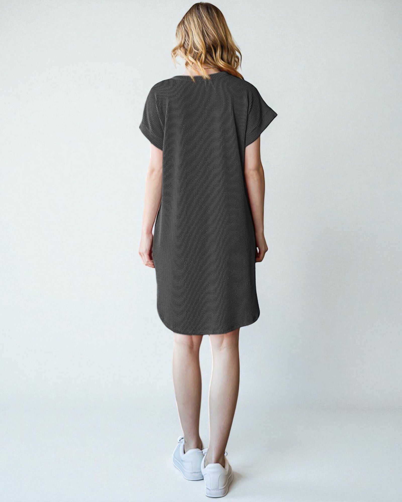 Woman wearing a gray dress against a white background