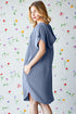 Woman wearing a blue dress against a colorful floral background