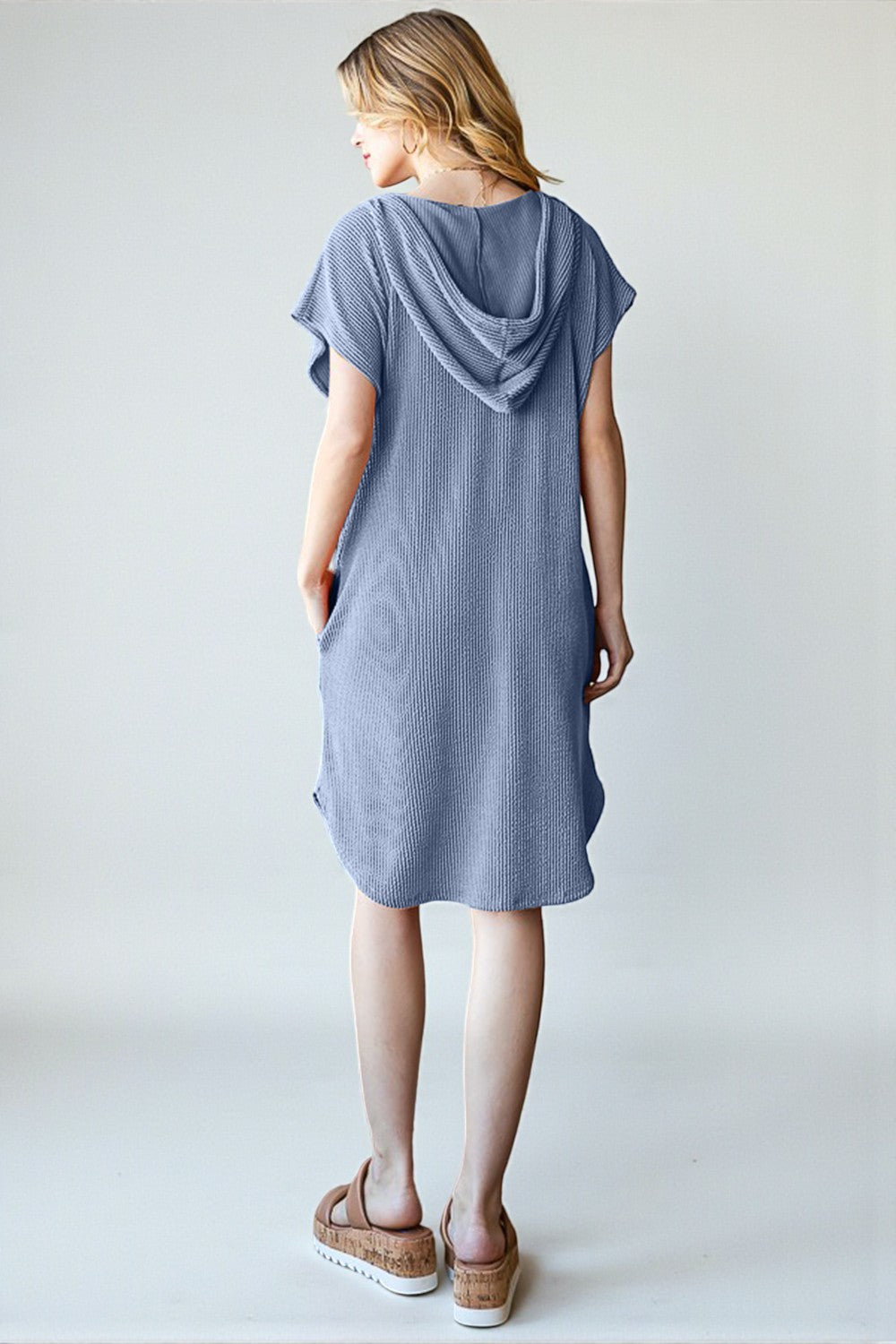 Woman wearing a blue dress against a white background