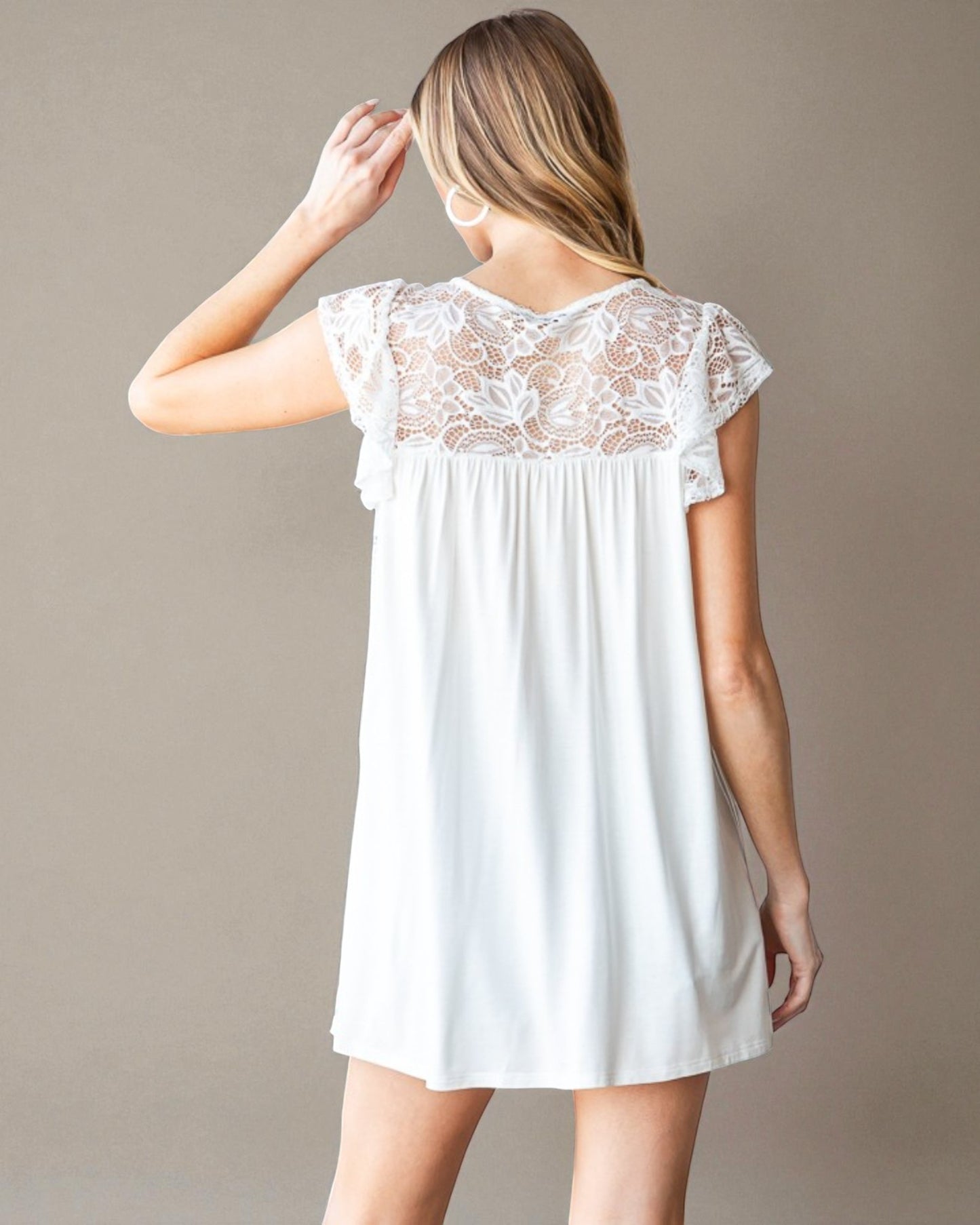 White lace nightgown worn by a person on a plain background