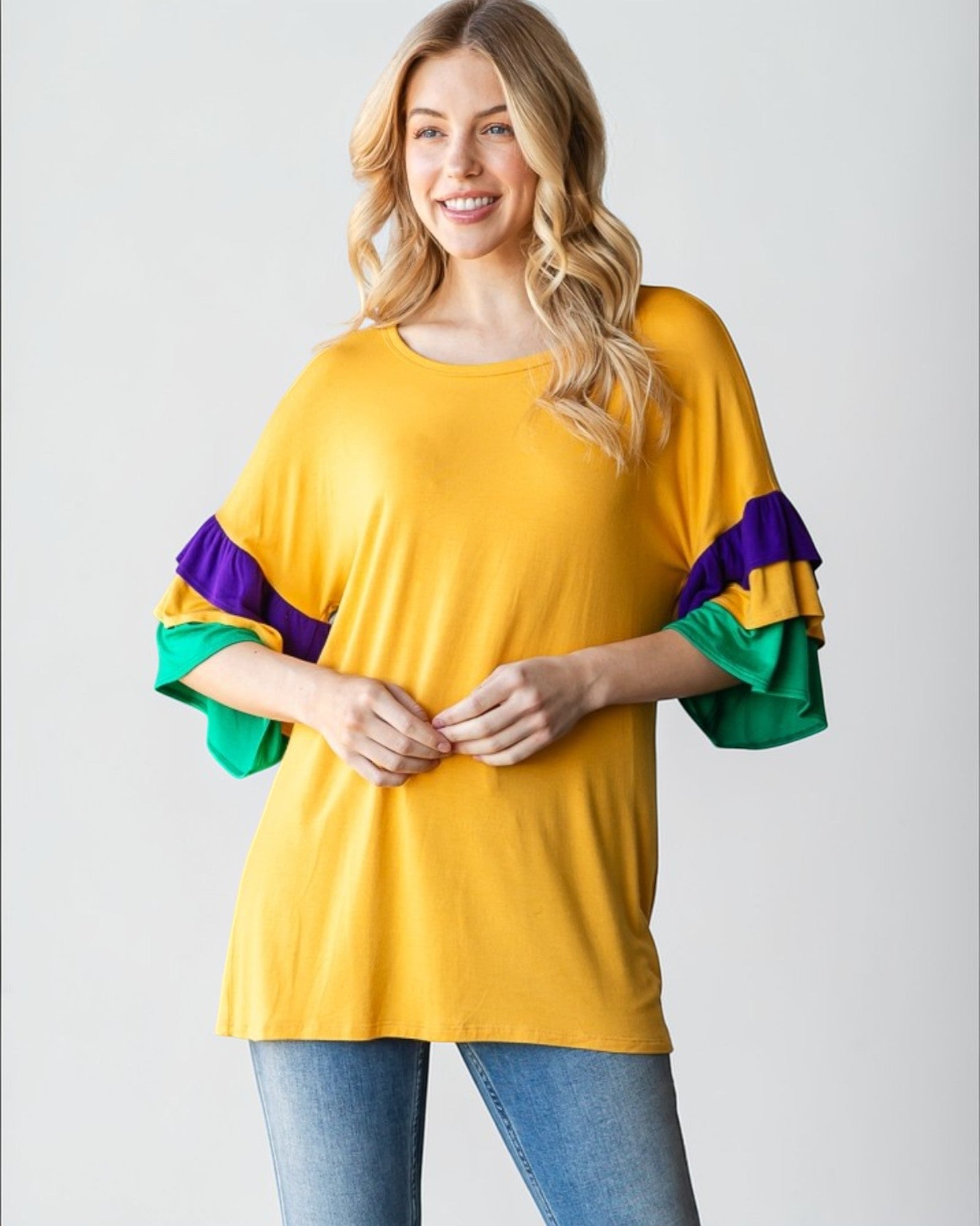 Woman wearing a yellow top with colorful sleeves on a white background