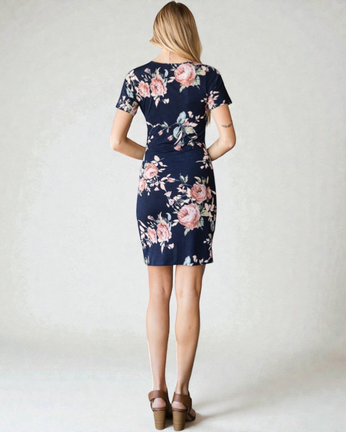 Woman wearing a navy floral dress on a white background