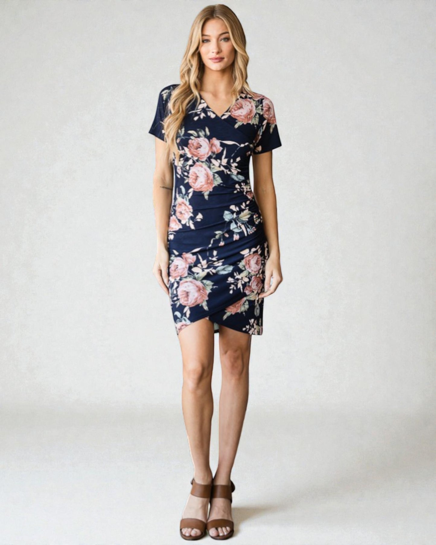 Woman wearing a navy floral dress on a white background