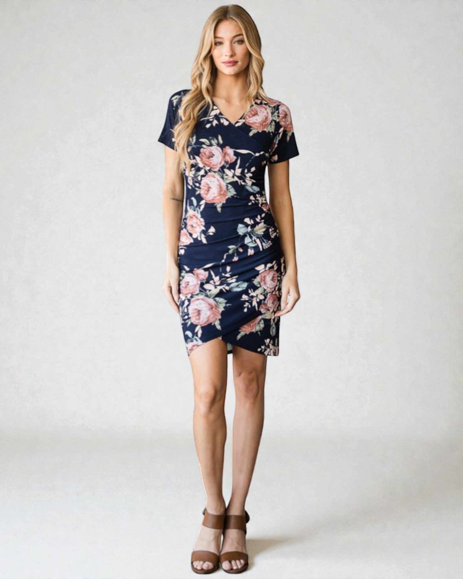 Woman wearing a navy floral dress on a white background