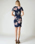 Woman wearing a navy floral dress on a white background