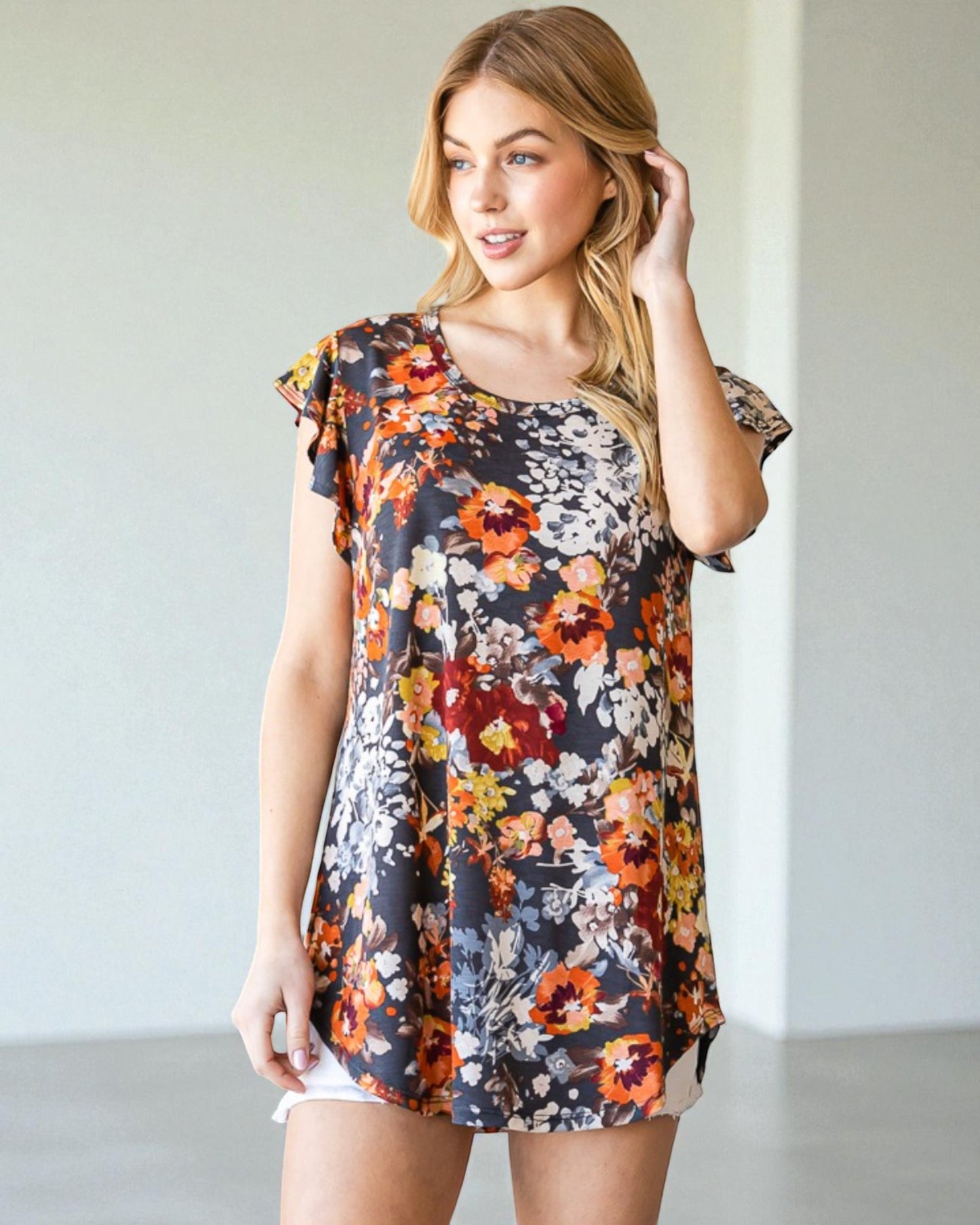 Woman wearing a floral dress against a plain background