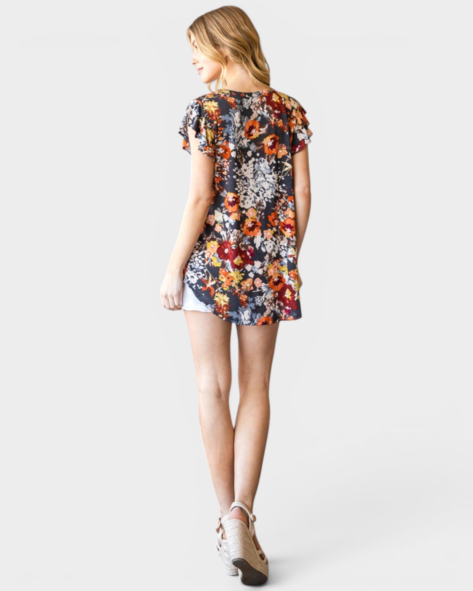 Woman wearing a colorful floral dress on a white background
