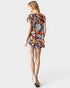 Woman wearing a colorful floral dress on a white background