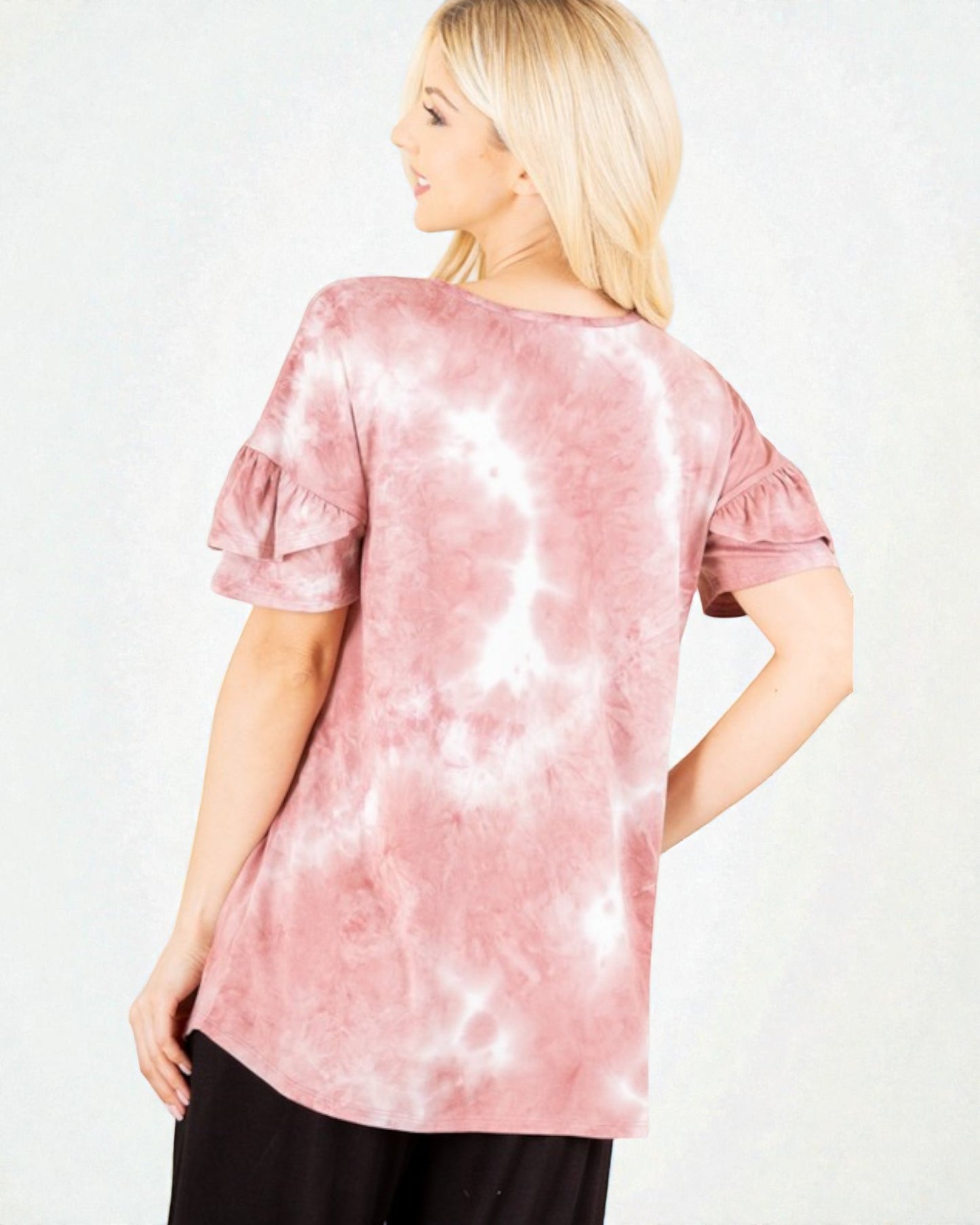Woman wearing a pink tie-dye shirt on a white background