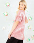 Woman wearing a pink tie-dye top with decorative stars on a light gray background