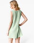 A woman shown from the back wearing a sleeveless, ribbed light green mini dress against a plain white studio background.