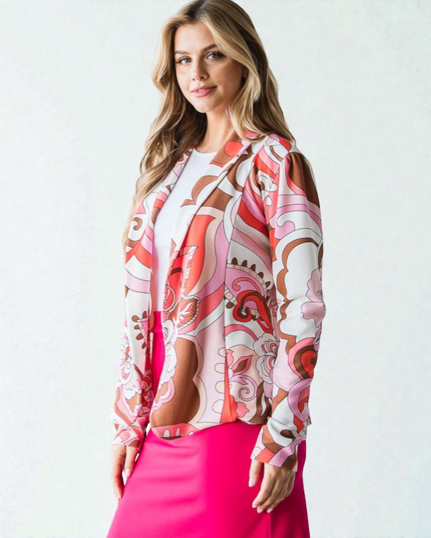 Woman wearing a patterned blouse with a pink skirt on a white background