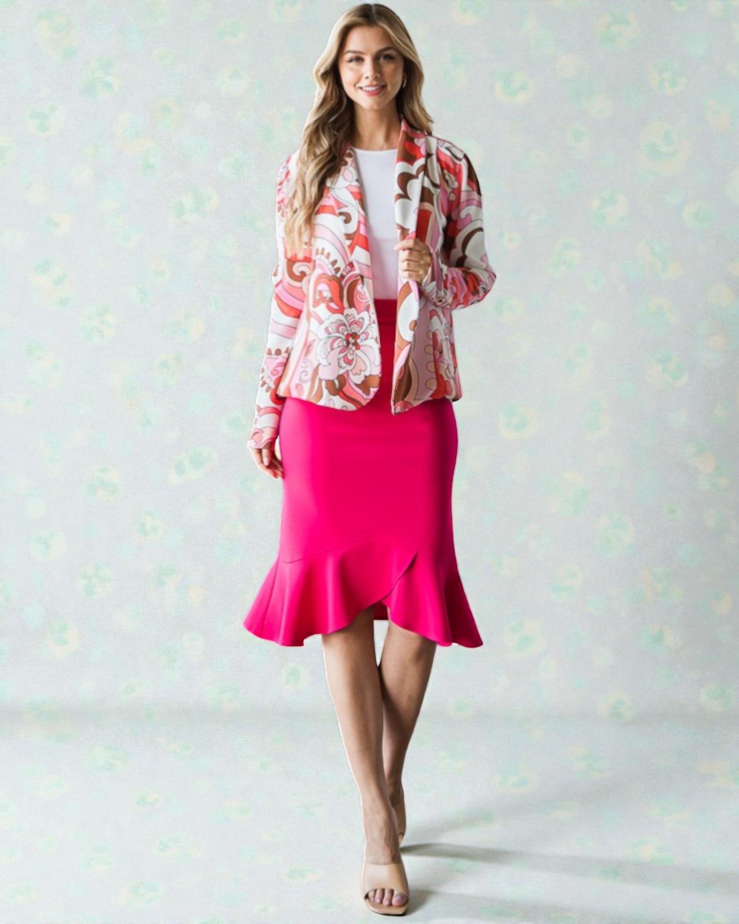 Woman wearing a floral jacket and pink skirt on a light background