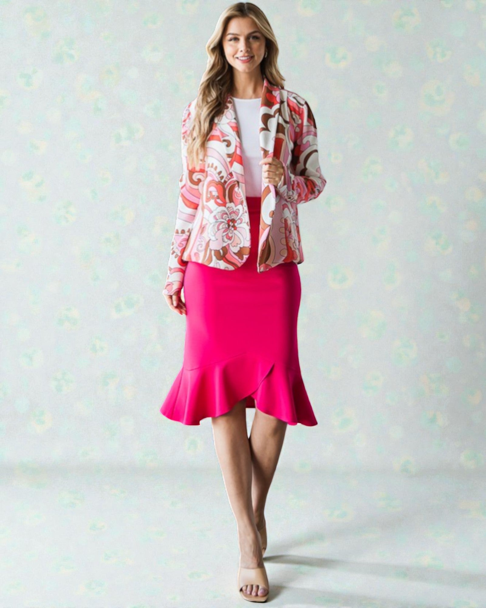 Woman wearing a floral jacket and pink skirt on a light background