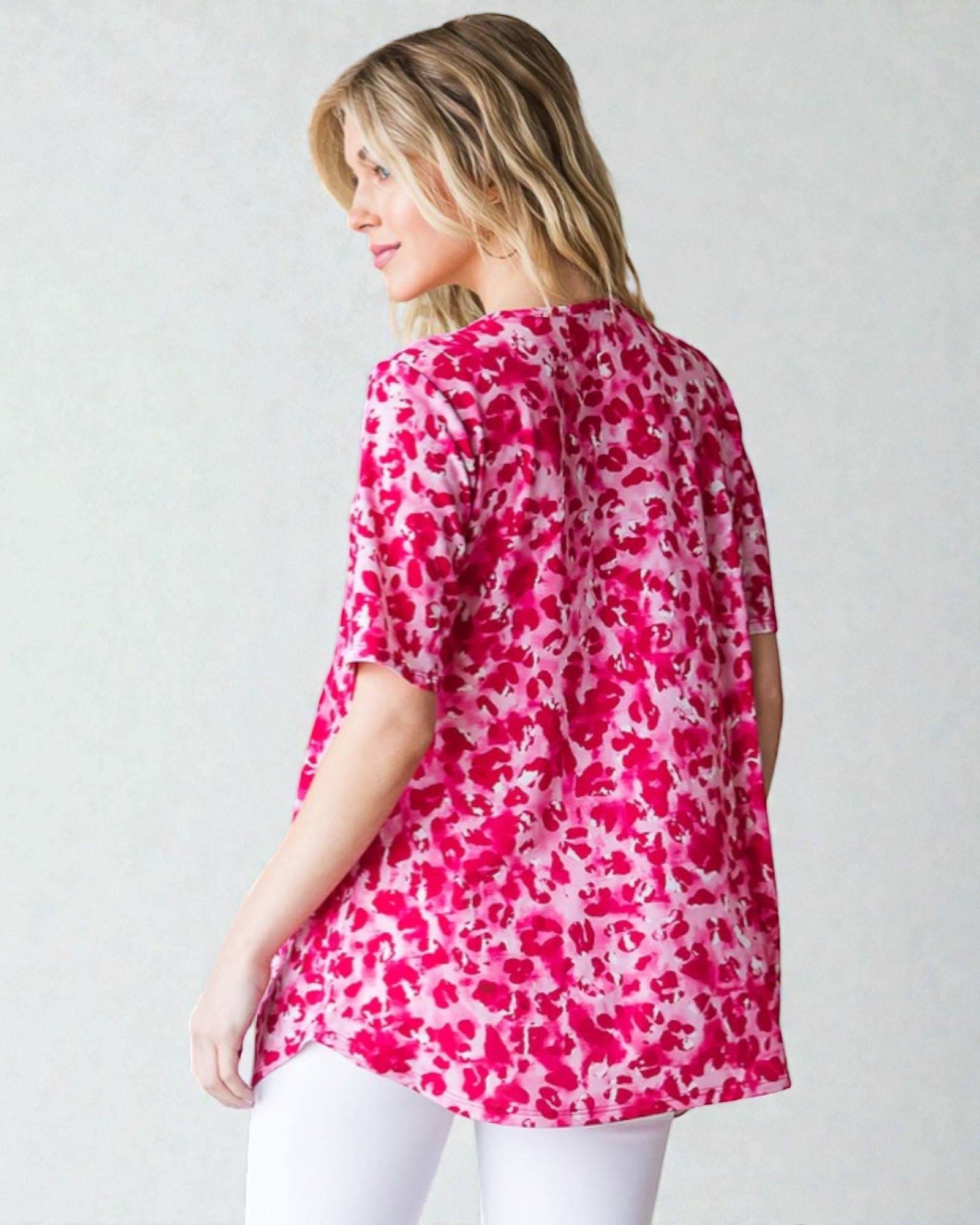Woman wearing a pink floral blouse against a white background