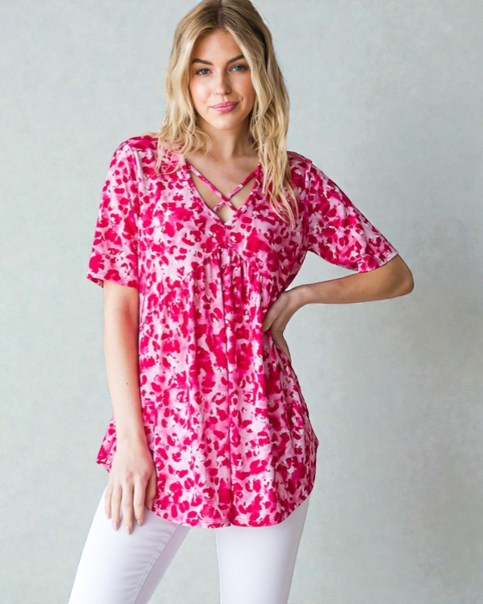Woman wearing a pink and white patterned blouse against a plain background