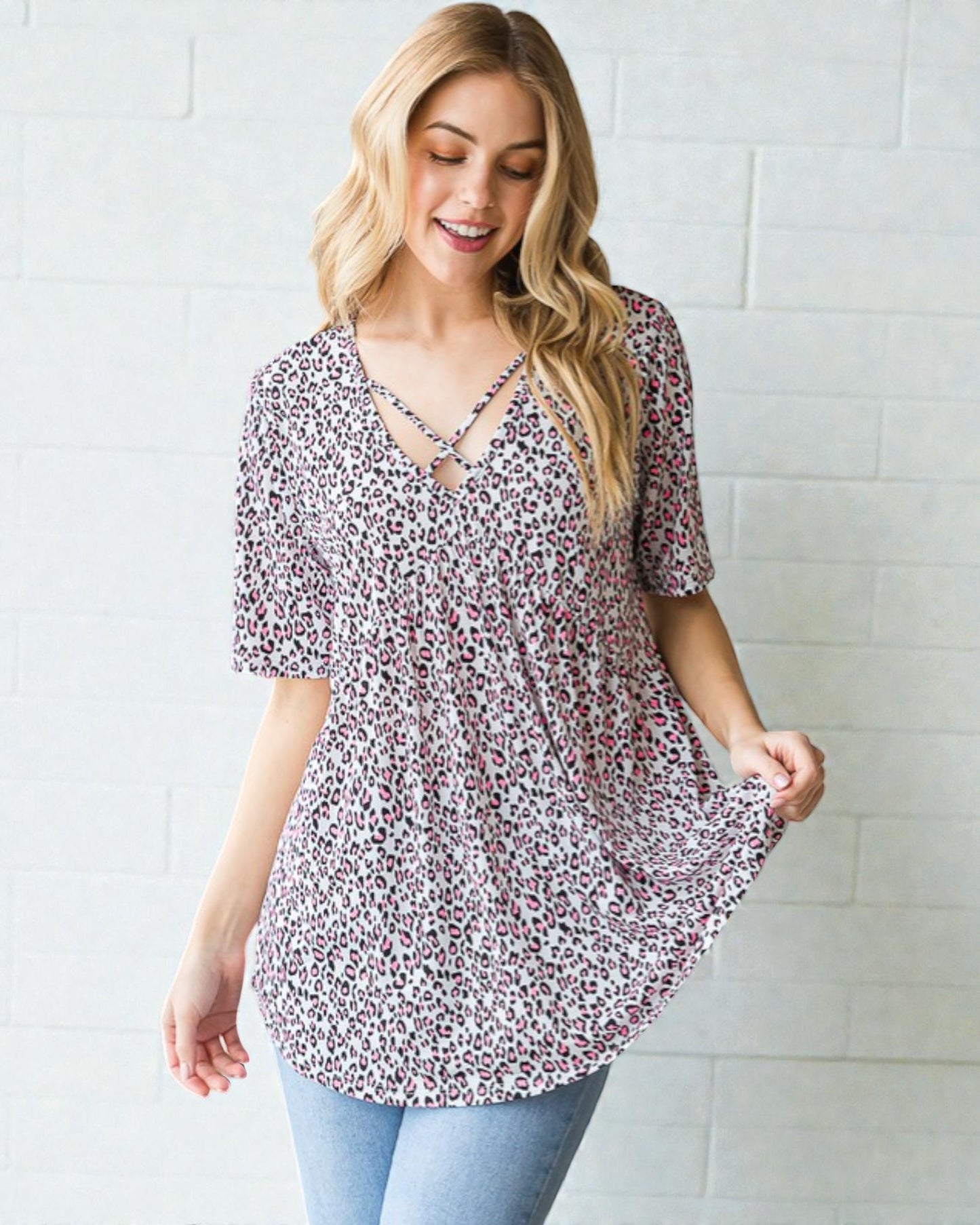 Woman wearing a floral blouse against a white tiled wall