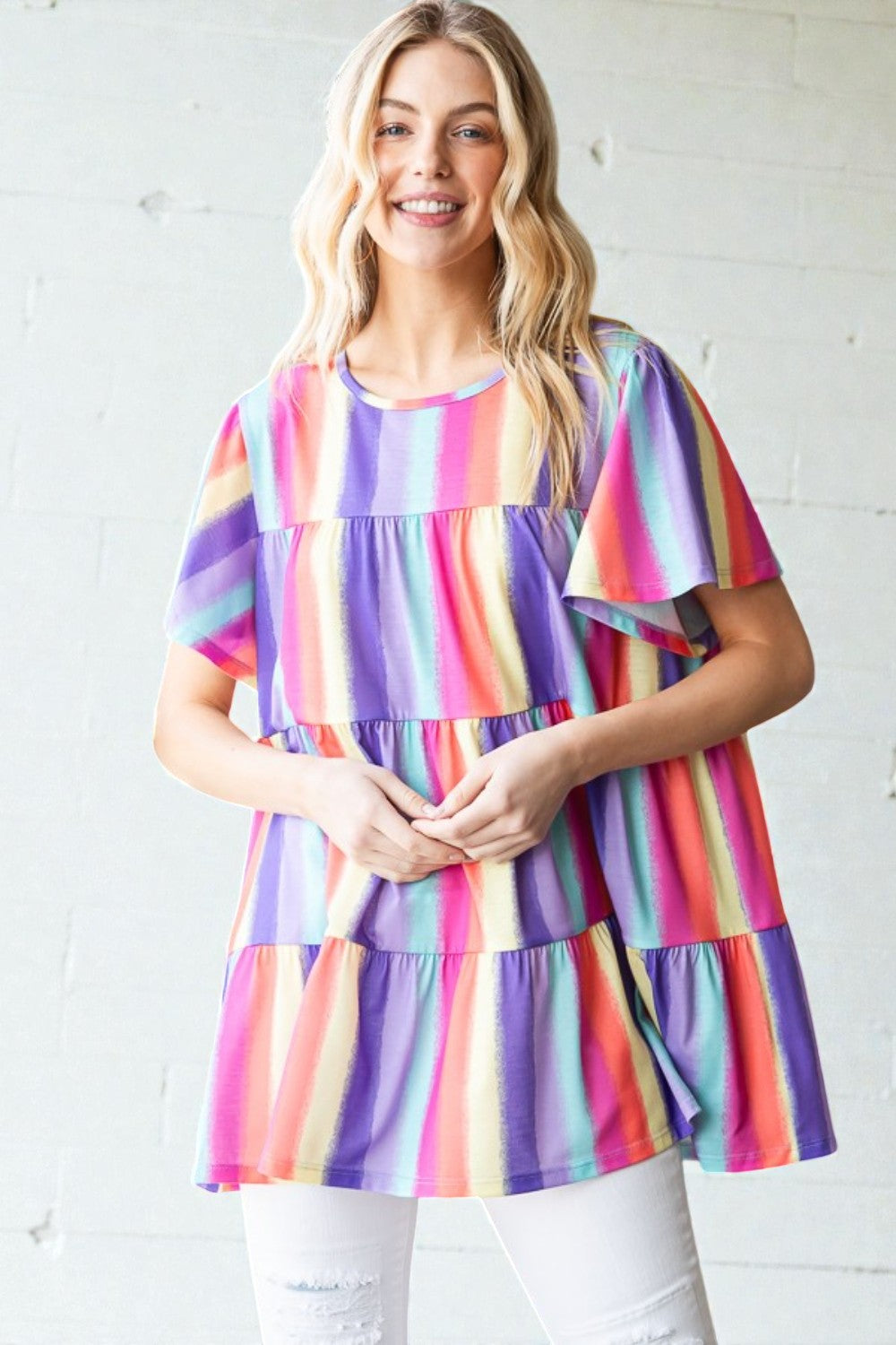 Woman wearing a colorful striped dress against a white background