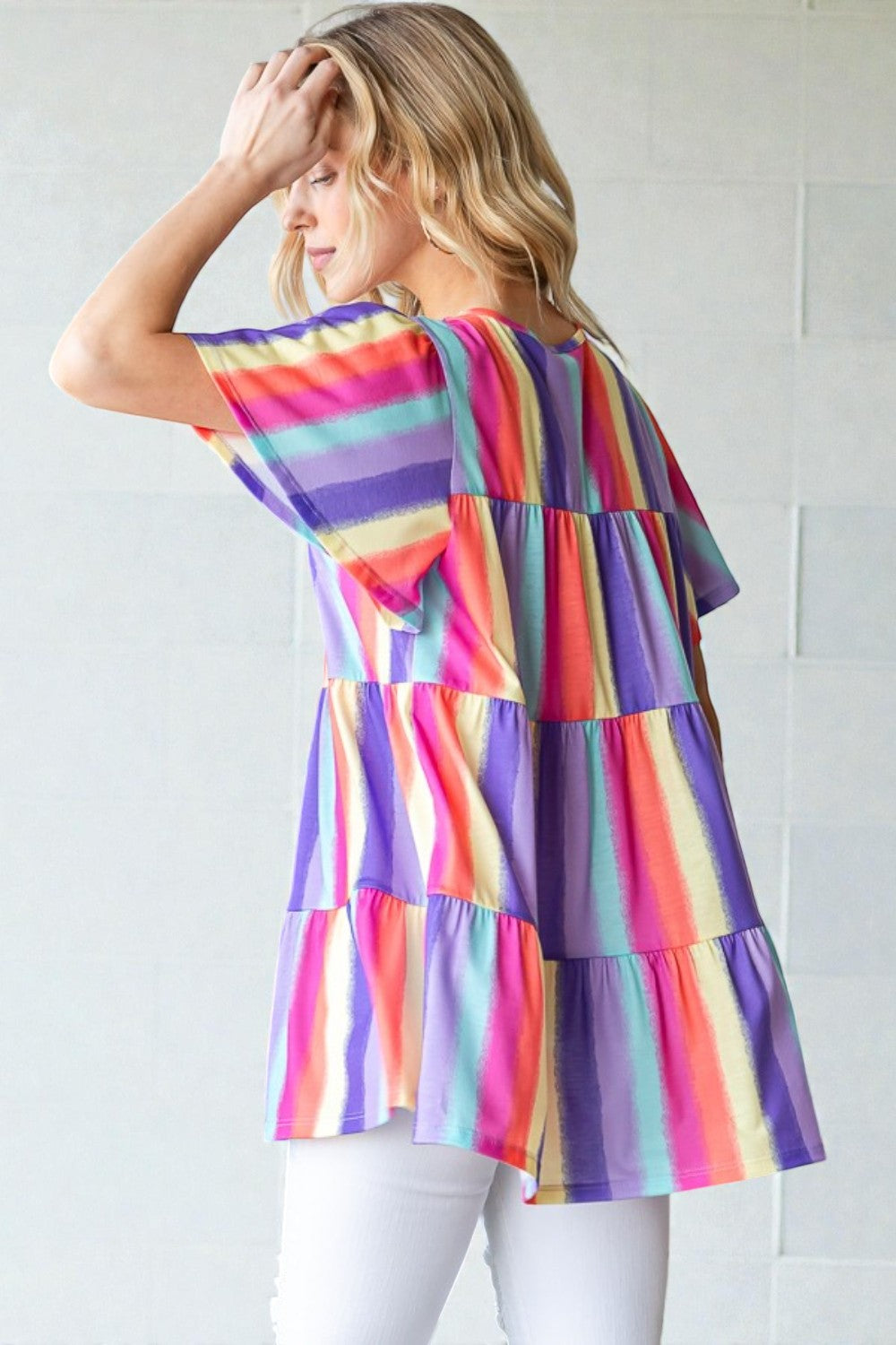 Woman wearing a colorful striped dress against a white background