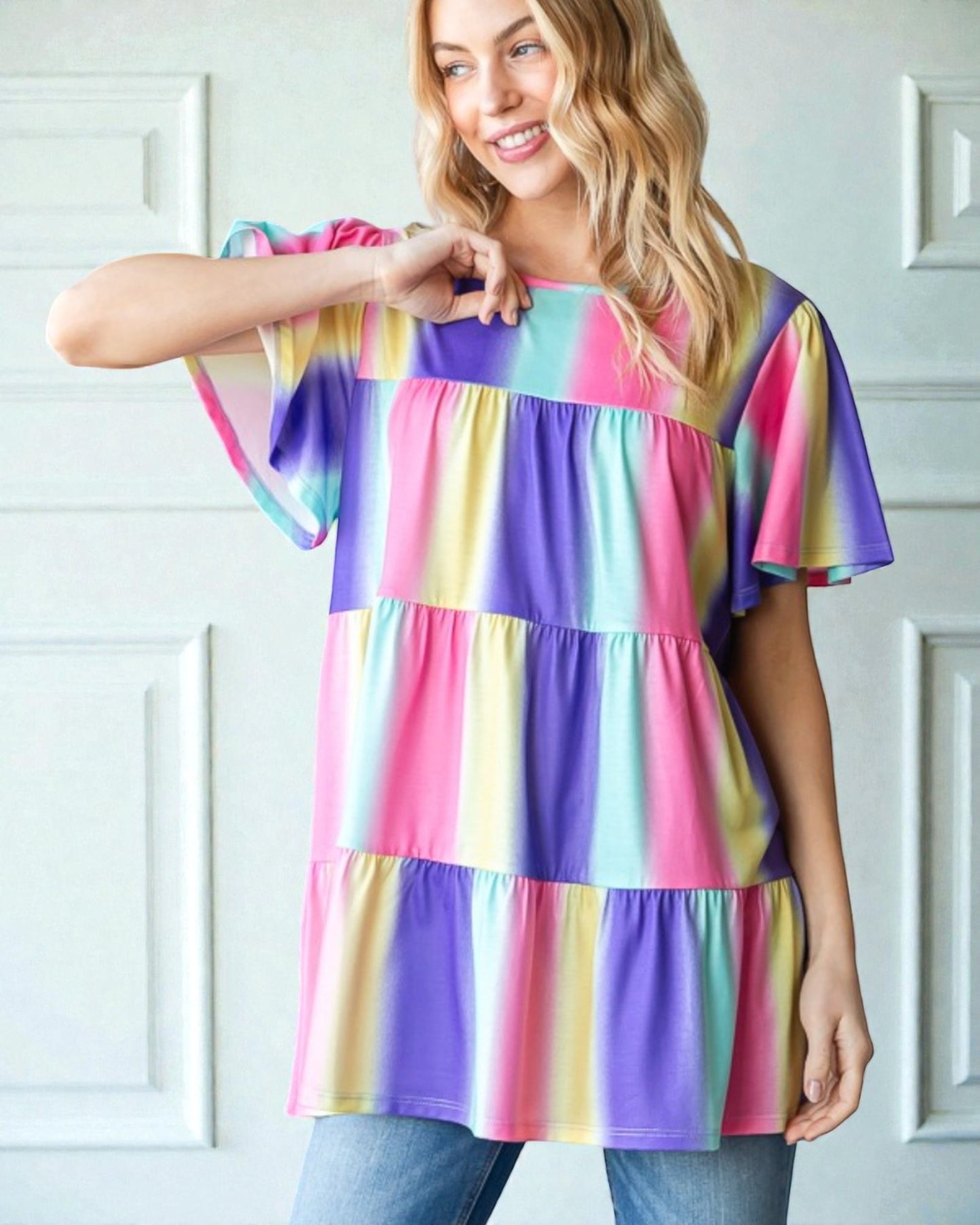 Woman wearing a colorful tiered dress against a white background