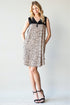 Woman wearing a black and white patterned dress on a plain background