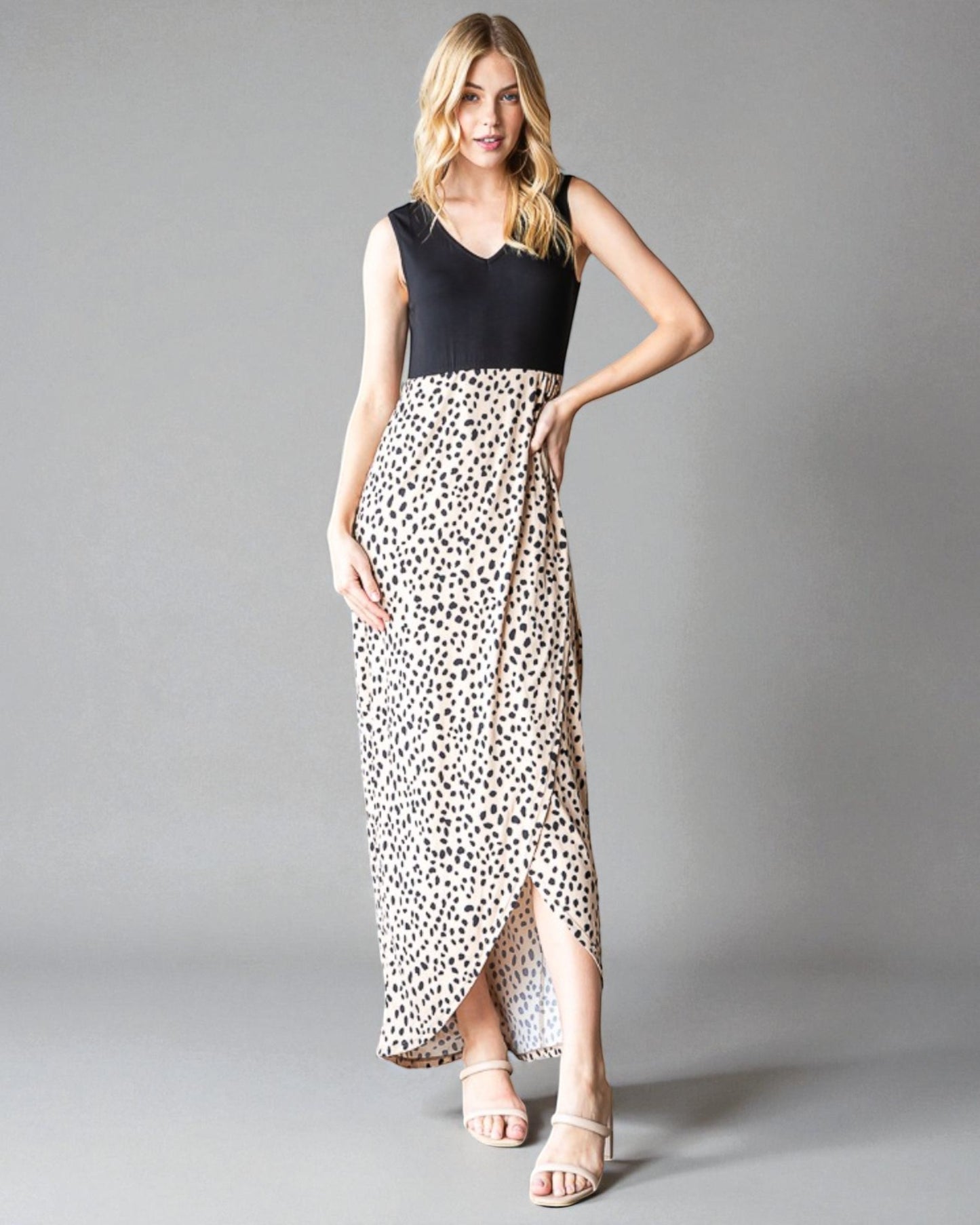 Woman wearing a black top and leopard print skirt on a gray background