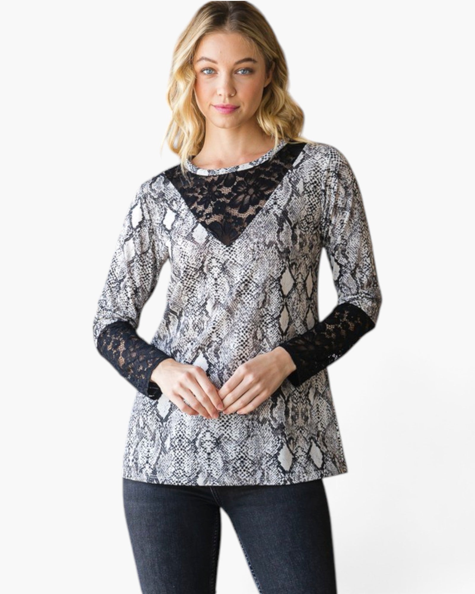 A woman modeling a long-sleeve top with a black and white snakeskin pattern, black lace V-neckline, and black lace elbow patches, paired with dark jeans against a plain white background.