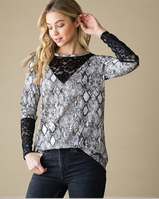 Woman wearing a snake print top with lace details on a beige background