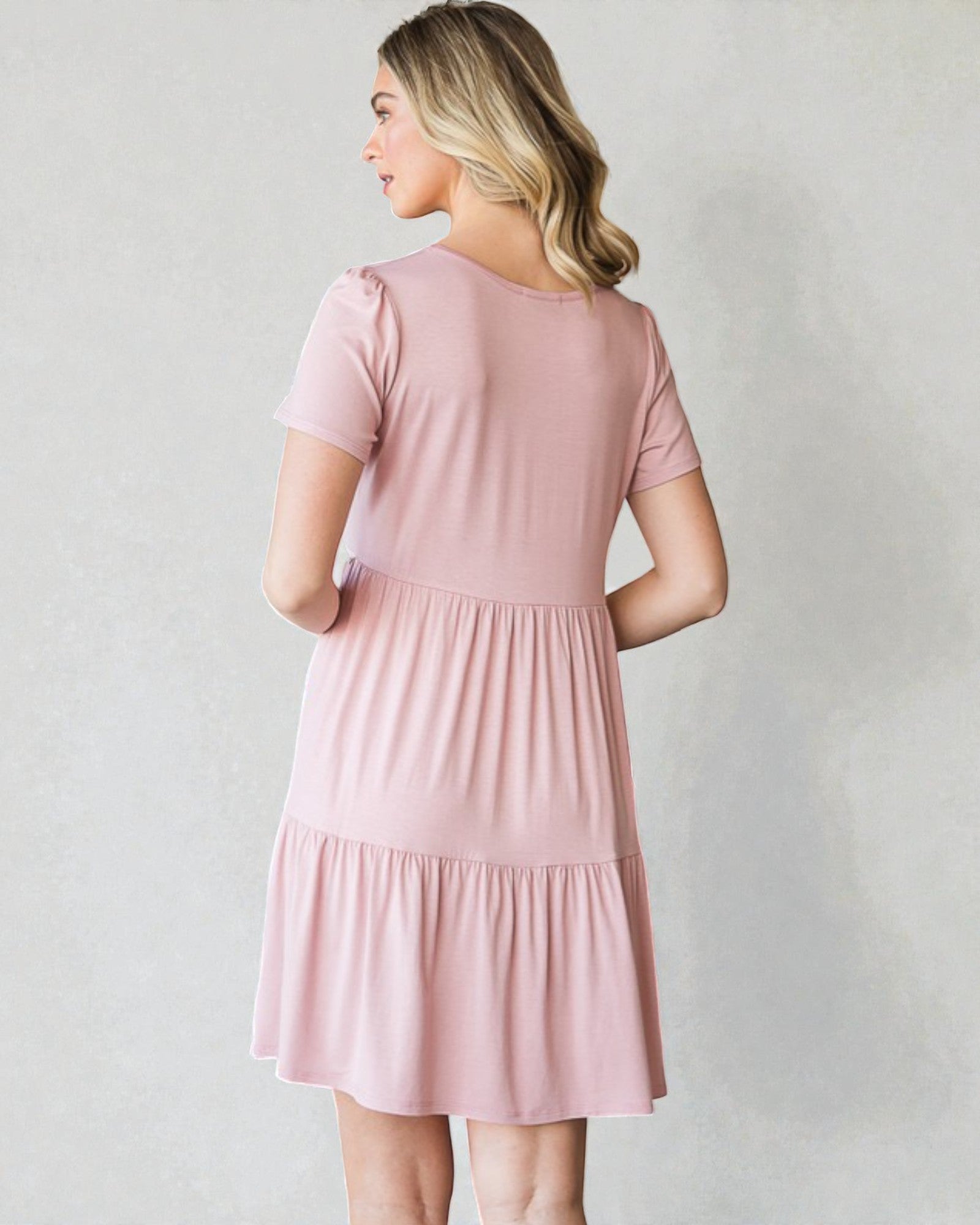 Woman wearing a pink dress against a plain background