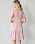 Woman wearing a pink dress against a plain background
