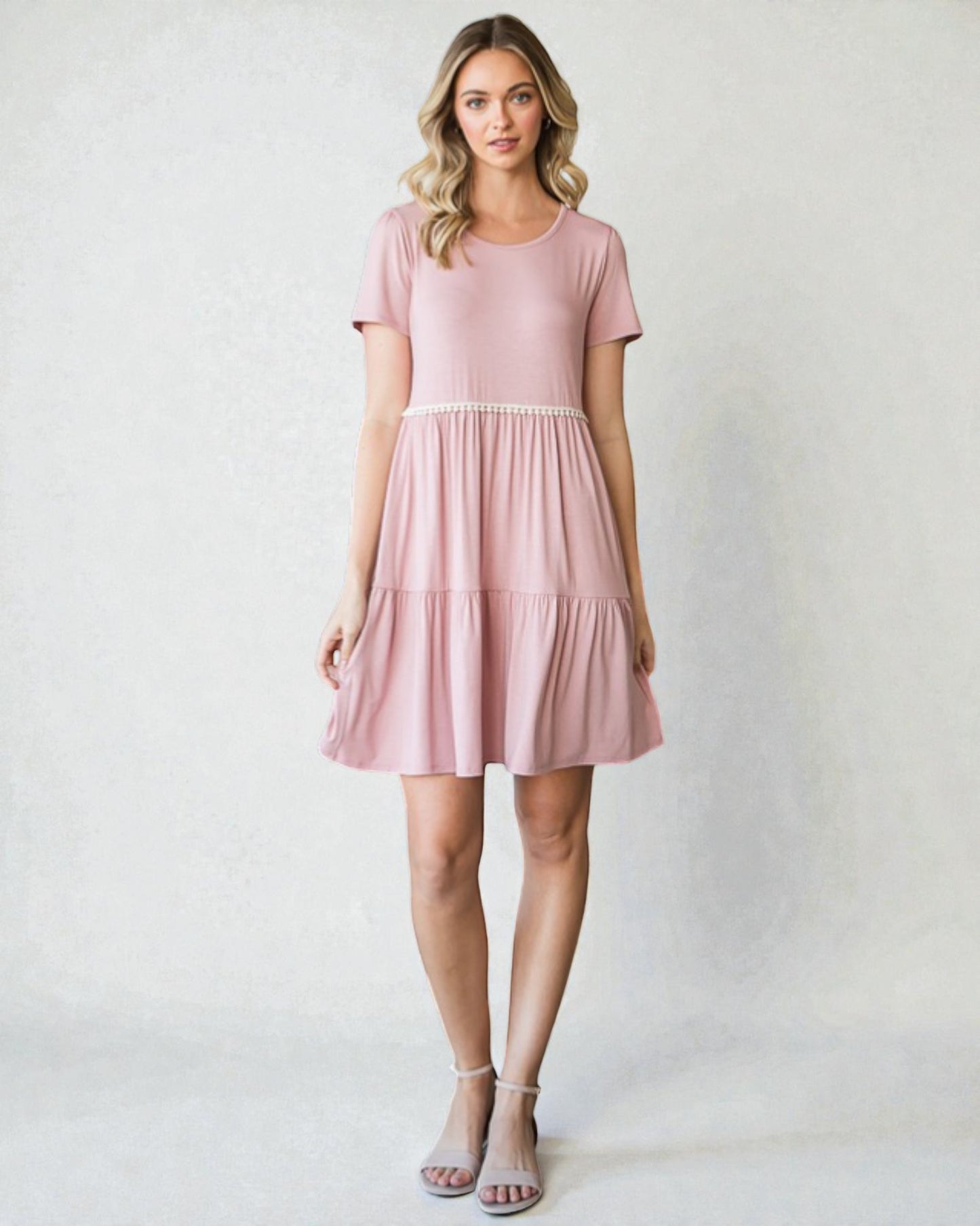 Woman wearing a pink dress against a plain background