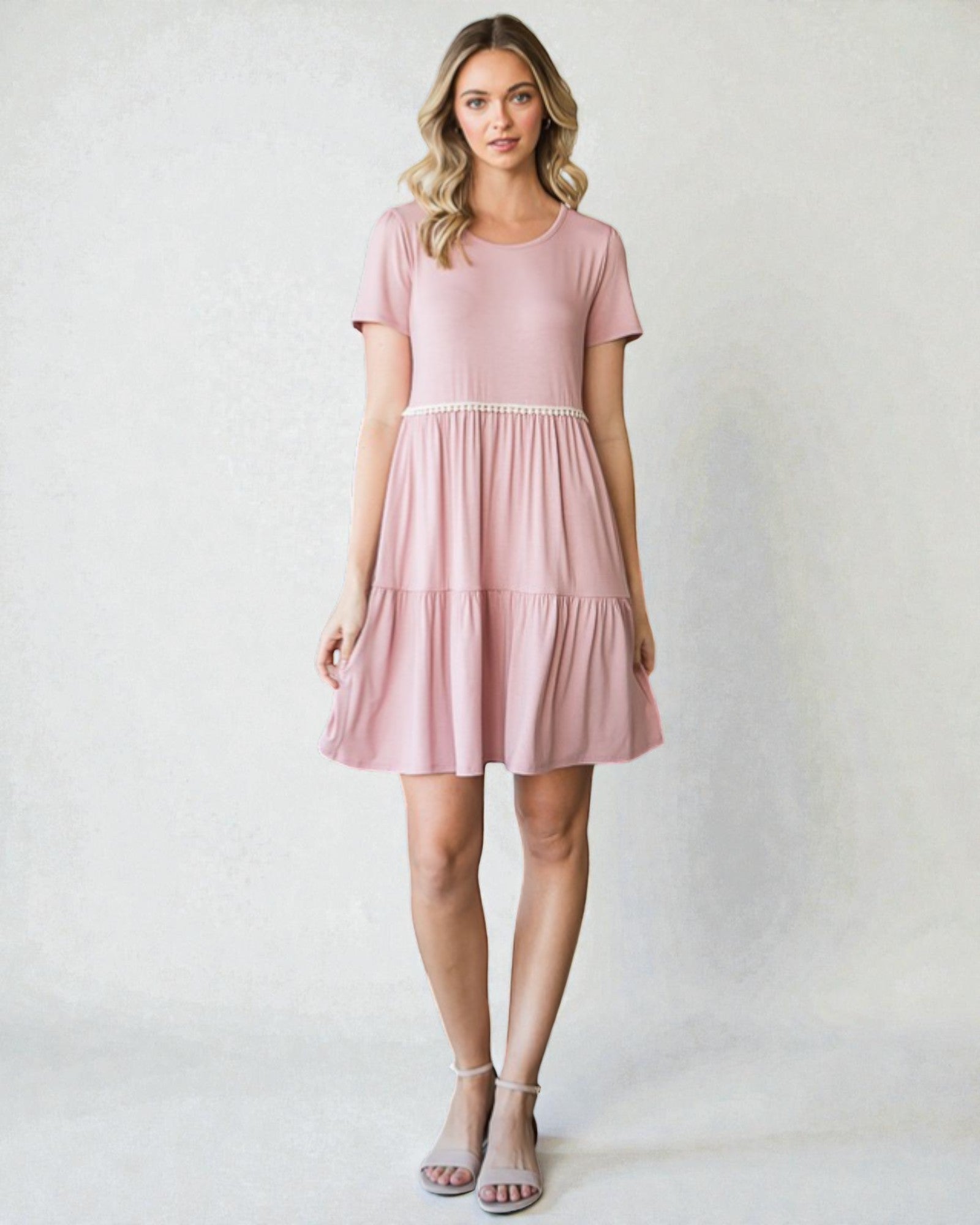 Woman wearing a pink dress against a plain background