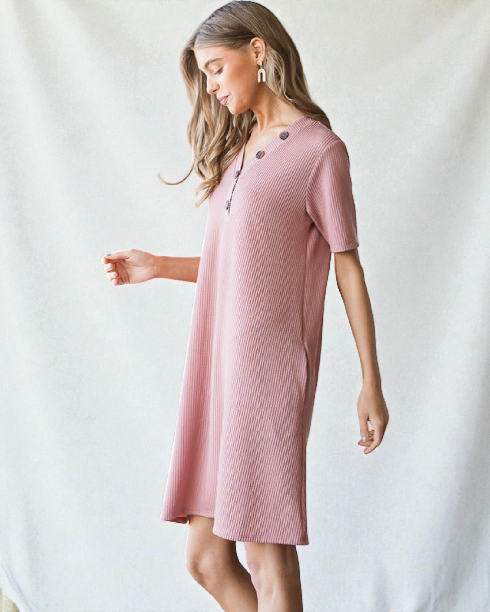 Woman wearing a pink dress against a white background