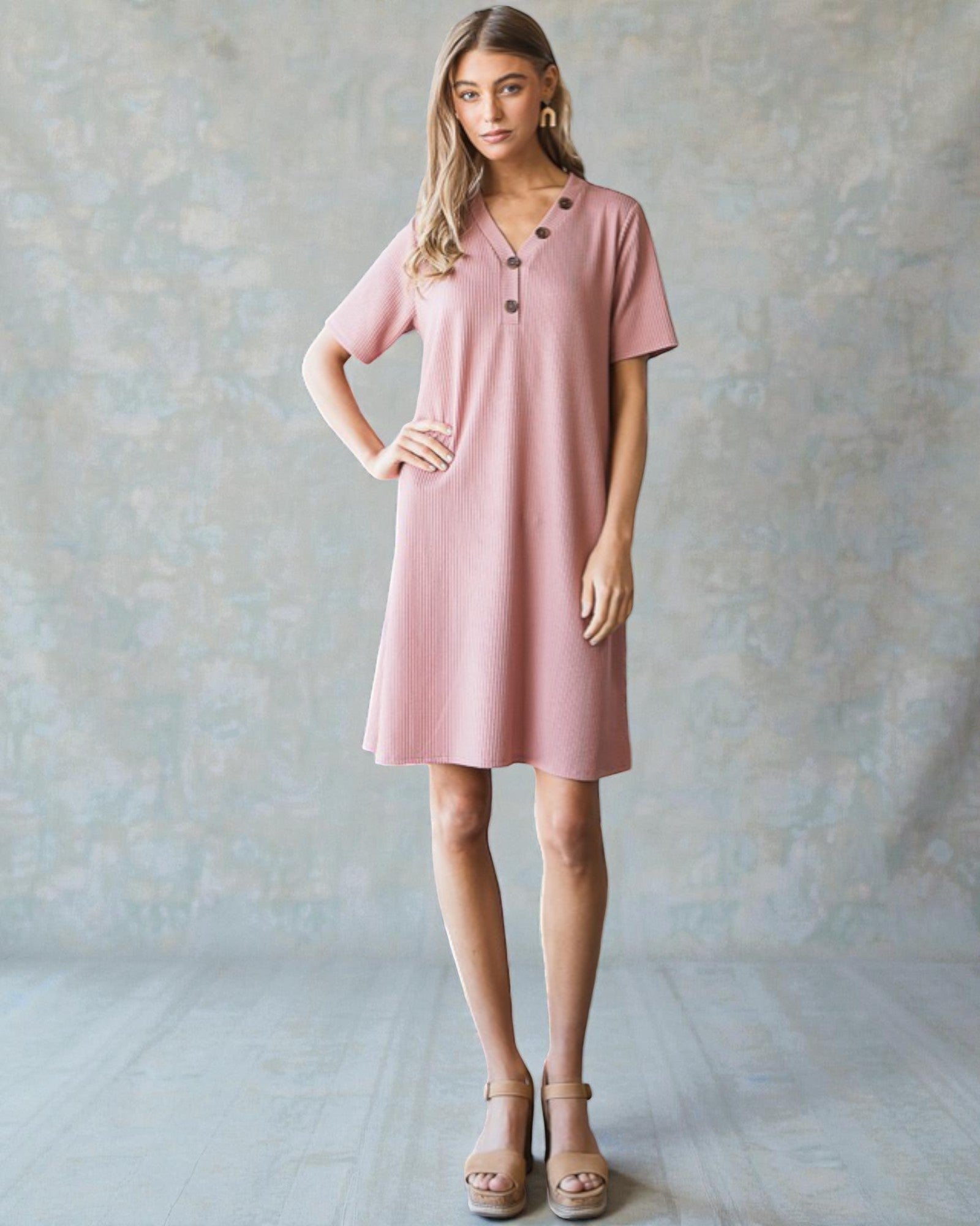 Woman wearing a pink dress against a plain background