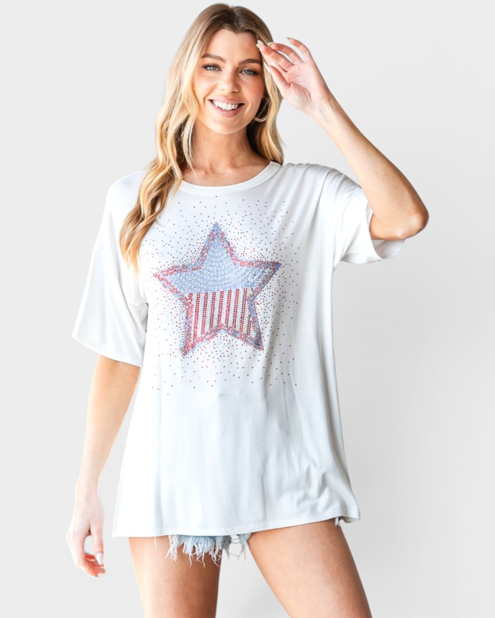 Woman wearing a white t-shirt with a star design on a plain background