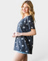 Woman wearing a navy blue t-shirt with white star patterns on a plain background