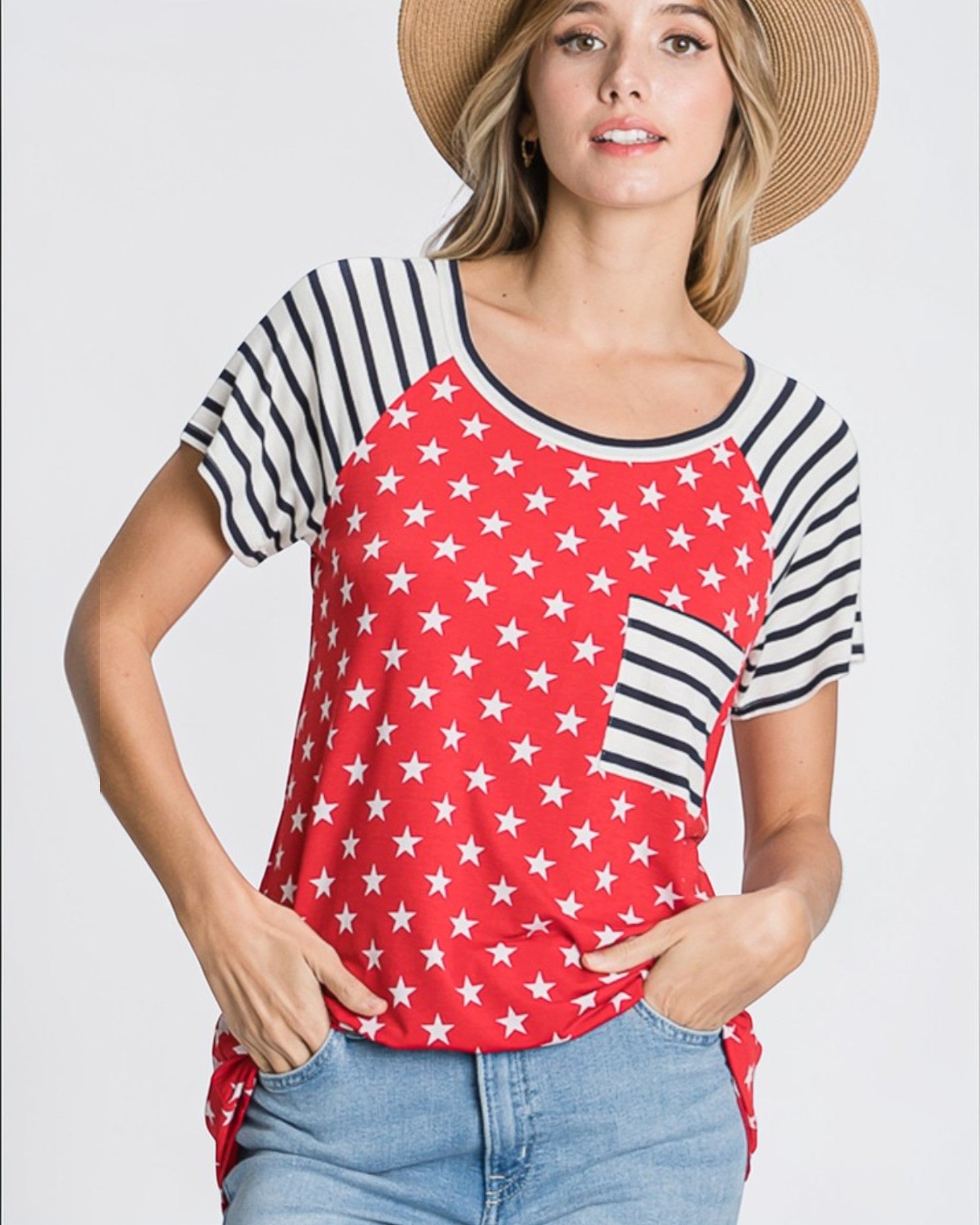 Woman wearing a red and white star-patterned shirt with black and white striped sleeves on a plain background