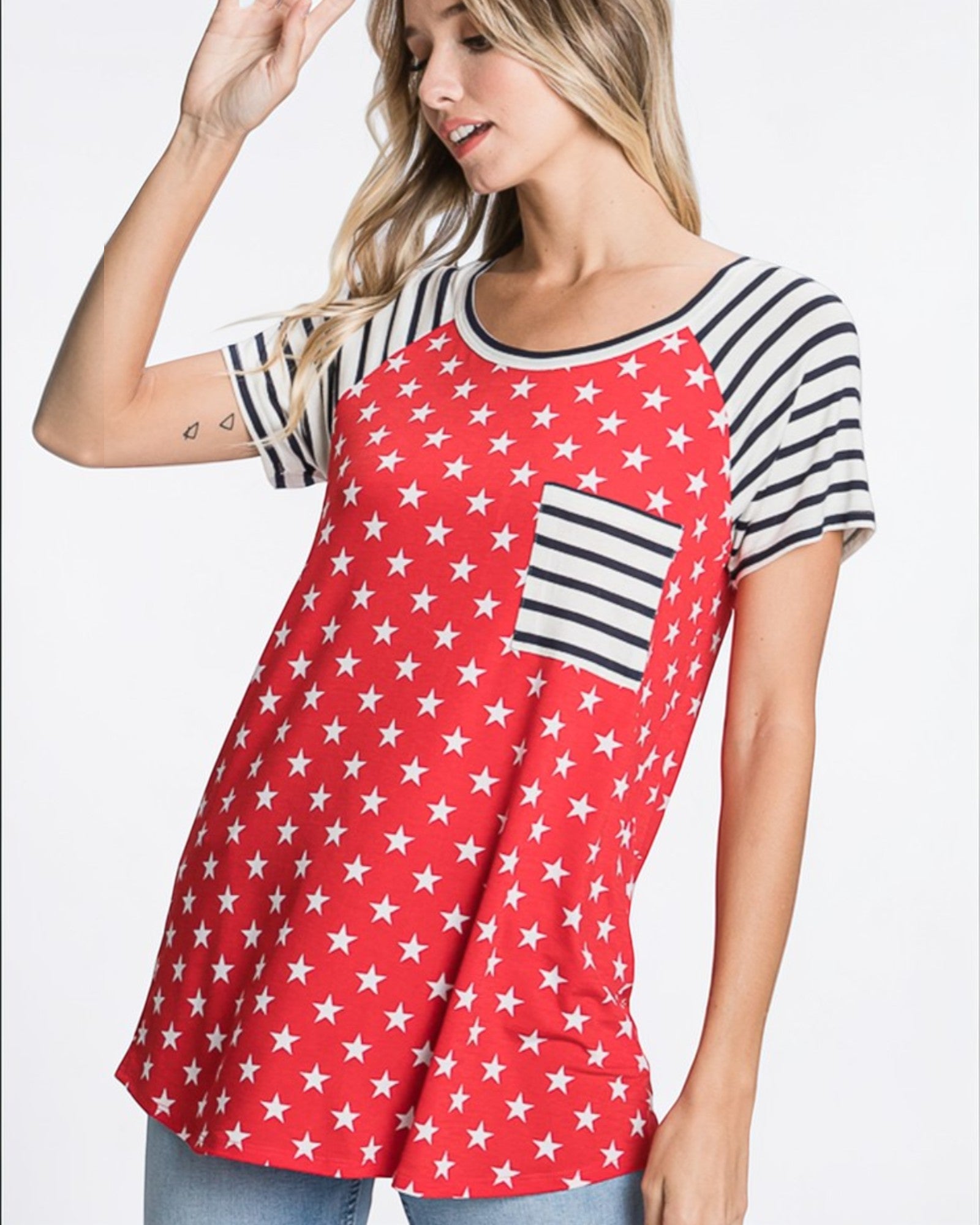 Woman wearing a red shirt with white star pattern and black and white striped sleeves on a white background