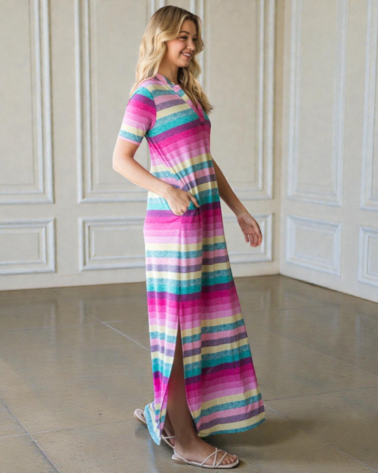 Woman wearing a colorful striped dress in a room with white paneled walls.