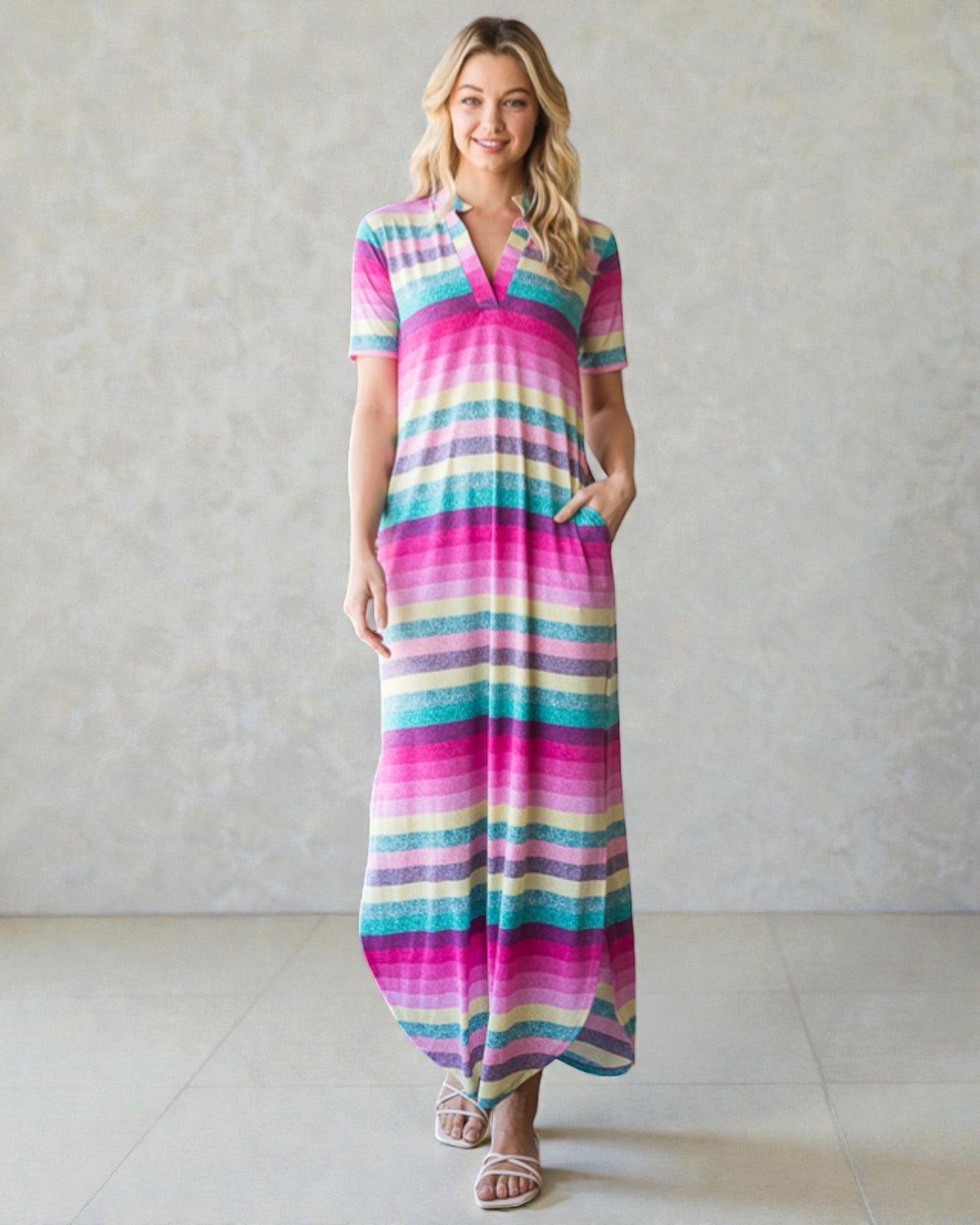 Woman wearing a colorful striped dress against a plain background