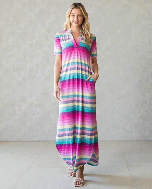 Woman wearing a colorful striped dress against a plain background