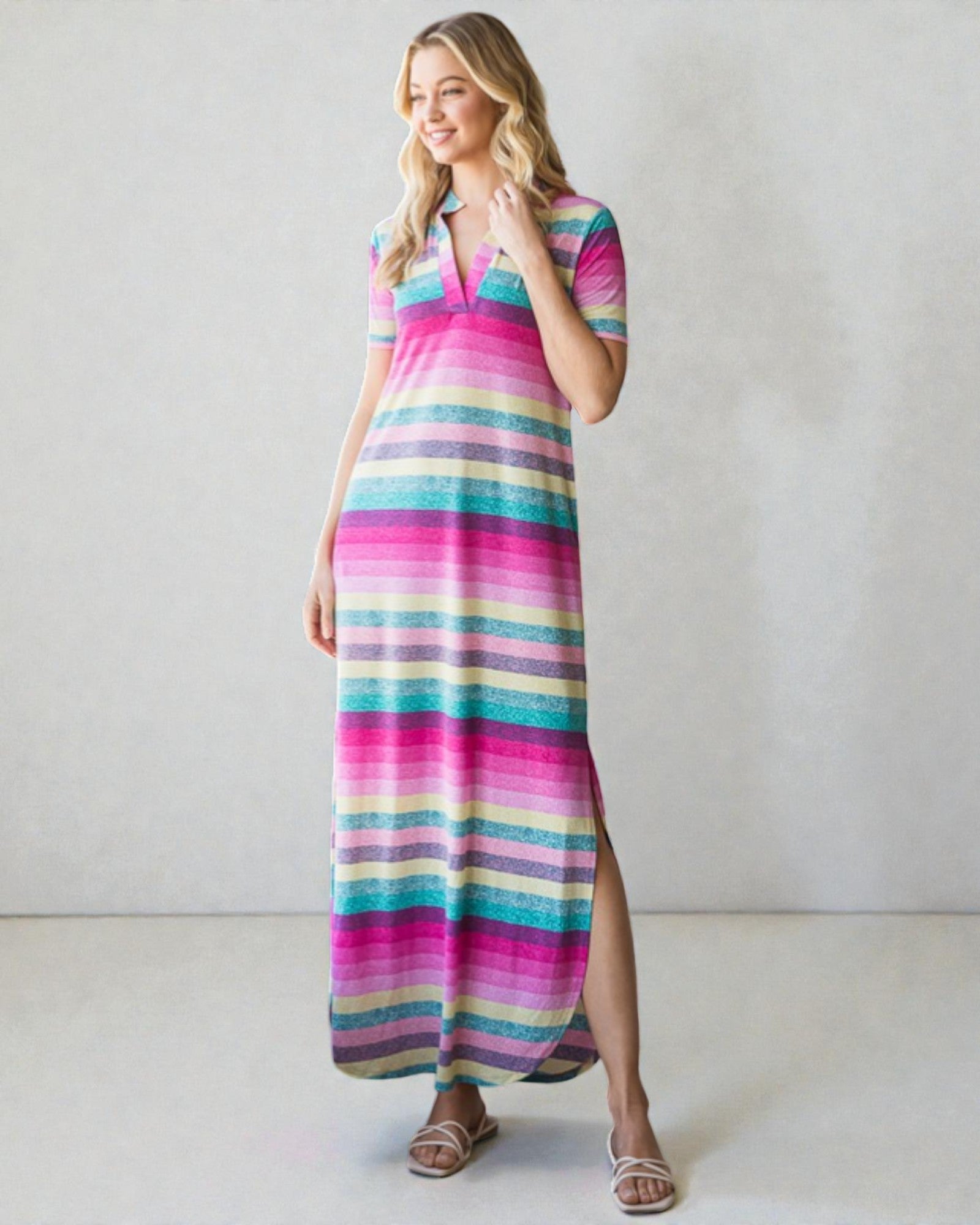 Woman wearing a colorful striped dress against a plain background