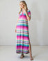 Woman wearing a colorful striped dress against a plain background