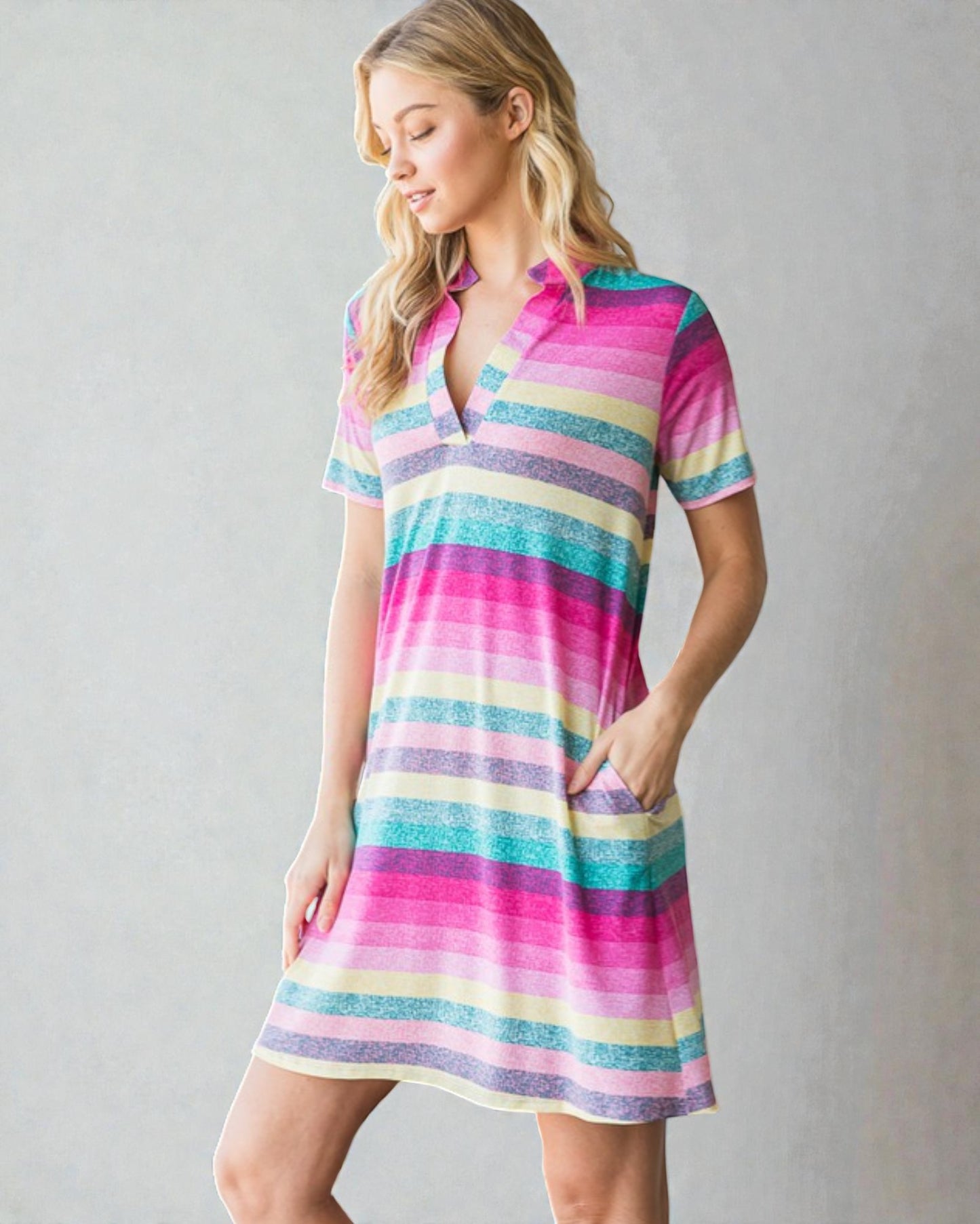 Woman wearing a colorful striped dress on a gray background
