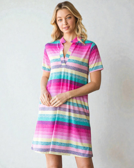 Woman wearing a colorful striped dress against a plain background