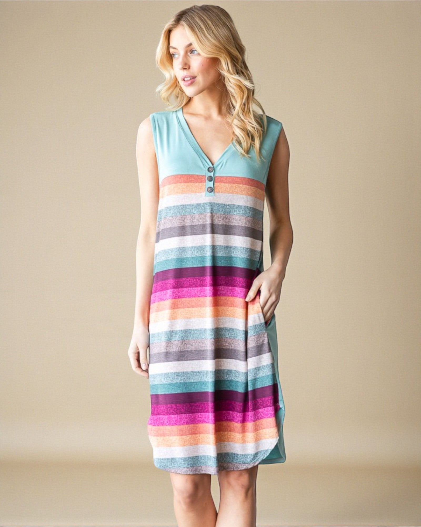 Woman wearing a colorful striped dress against a beige background