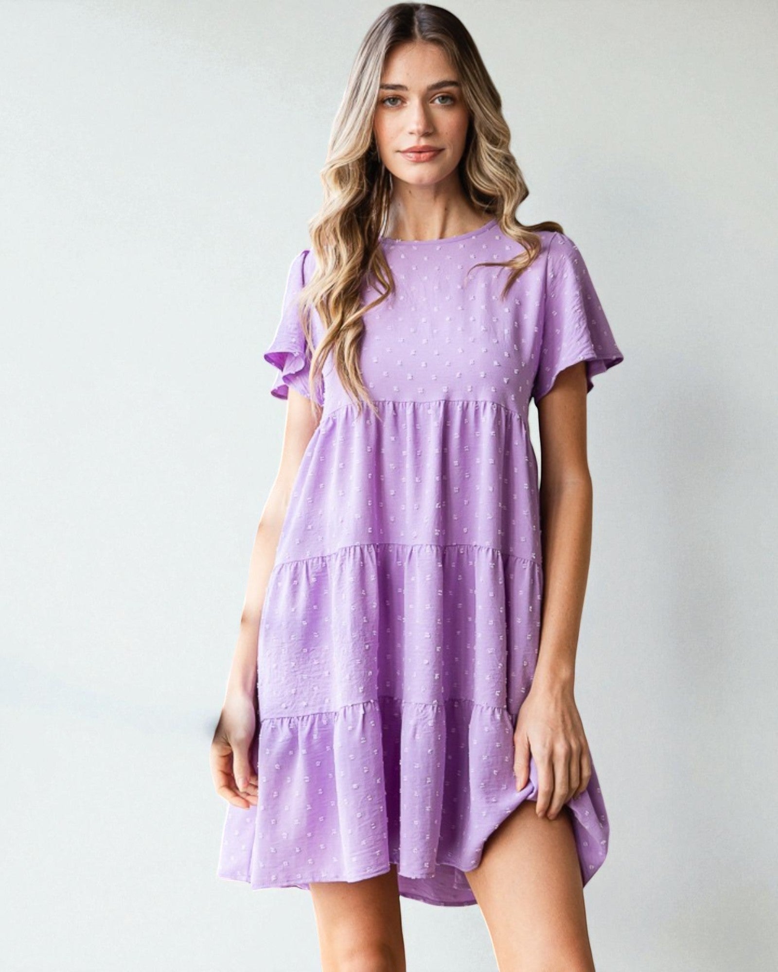 Woman wearing a purple dress against a plain background
