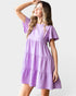 Woman wearing a purple dress against a white background