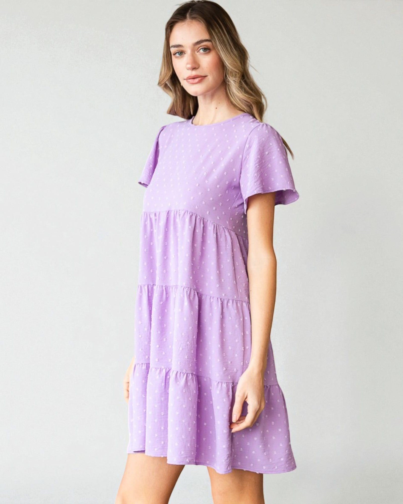 Woman wearing a purple dress with a white background